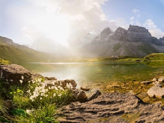 bEin Bild von einer Urner Berglandschaft mit einem idyllischen Bergsee im Zentrum.